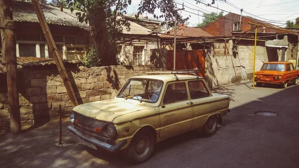 Horizontale Aufnahme eines alten weißen und eines alten roten Autos in einem Dorf in Armenien — Stockfoto