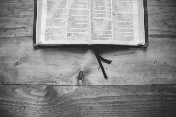 Tiro aéreo de um livro aberto em uma superfície de madeira em preto e branco — Fotografia de Stock