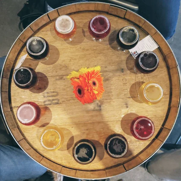 円形にビールグラスが並ぶ木製の樽のオーバーヘッドショット。 — ストック写真