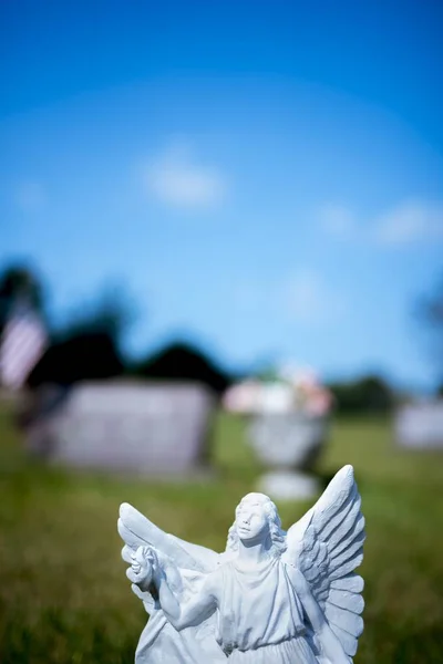 Függőleges felvétel egy nappali homályos hátterű angyalszoborról — Stock Fotó