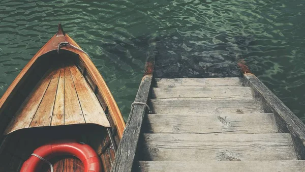 High angle shot of a small boat near the wooden stairs in the beautiful sea