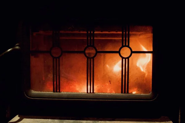Närbild skott av brand brinner i en öppen spis med ett metalliskt staket — Stockfoto