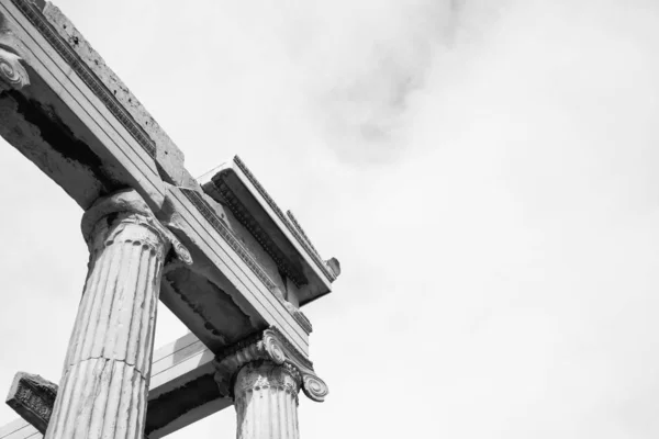 Bajo ángulo blanco y negro plano de pilares de un antiguo templo en Atenas, Grecia — Foto de Stock