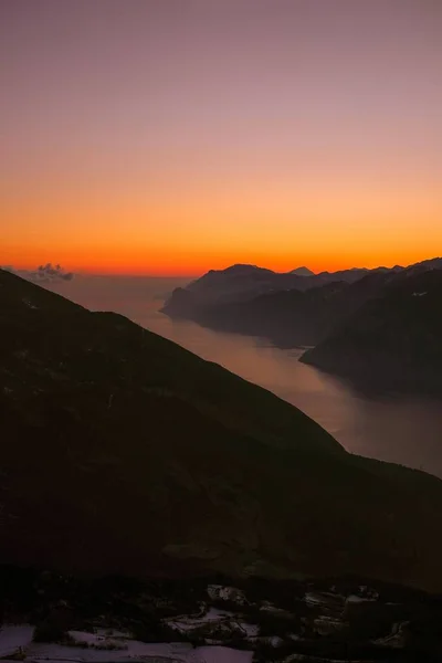 日没時の水の近くの山の形成の風景のシルエット — ストック写真