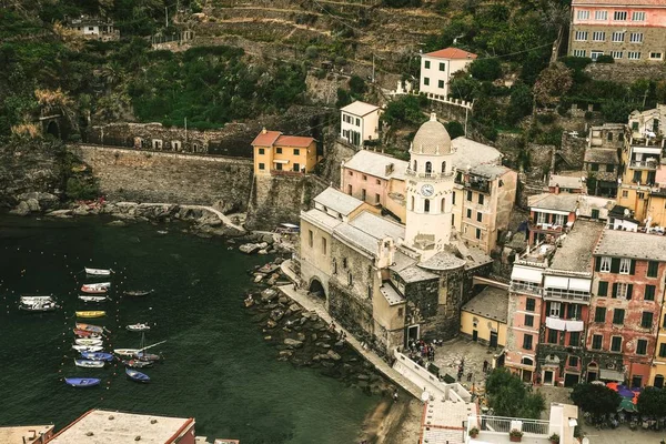 Tiro de alto ângulo de edifícios coloridos perto da água com barcos em Vernazza, Itália — Fotografia de Stock