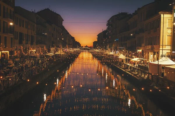 Reflective shot of string lights above river between the buildings during Christmas at night — Stock Photo, Image