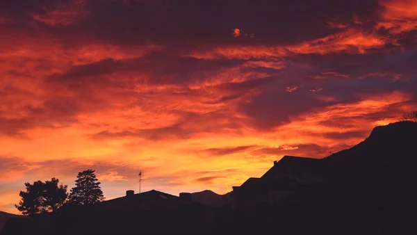 Σιλουέτα των σπιτιών στο λόφο κάτω από τον όμορφο πολύχρωμο ουρανό το βράδυ — Φωτογραφία Αρχείου