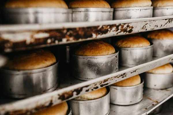 Closeup shot of cakes in metallic molds being baked in an oven