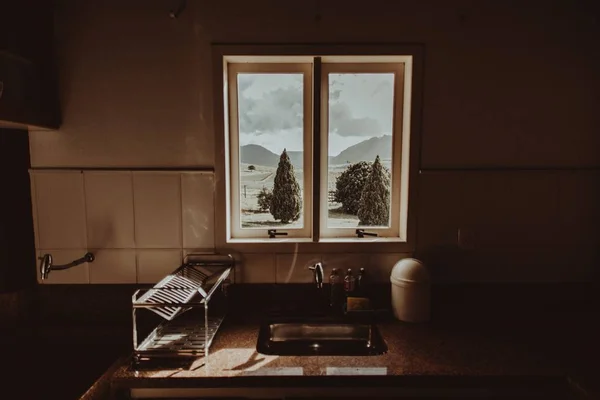 Vue horizontale d'un évier avec une petite fenêtre où un jardin est visible — Photo