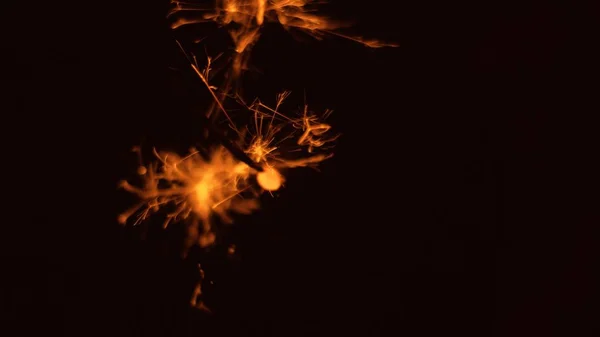 Selective shot of holiday sparkler fireworks in a pitch-black background — Stock Photo, Image