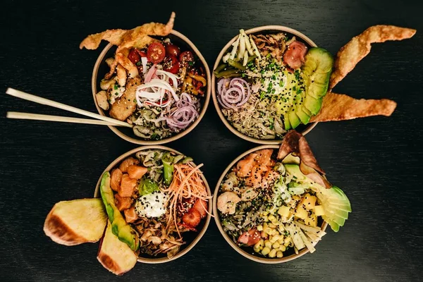 Overhead closeup shot of four bowls of food with chopsticks in one of them — Stock Photo, Image
