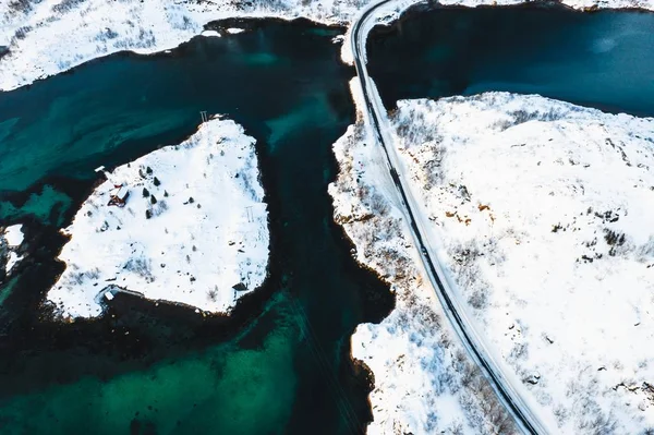 Vue aérienne d'une route traversant des îles enneigées sur un plan d'eau — Photo