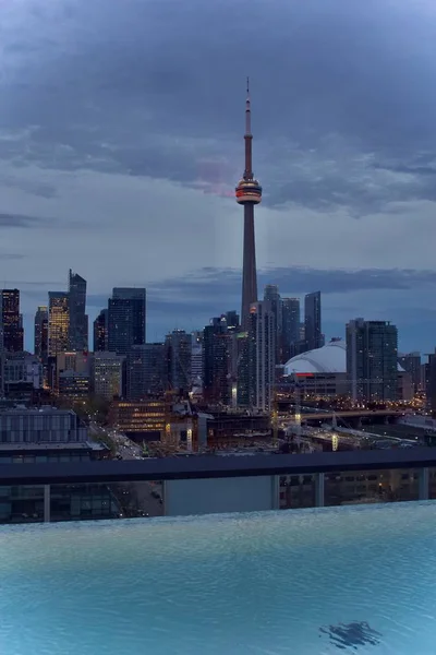 Plan vertical tiré d'une piscine d'une ville avec des gratte-ciel et une haute tour visible en arrière-plan — Photo