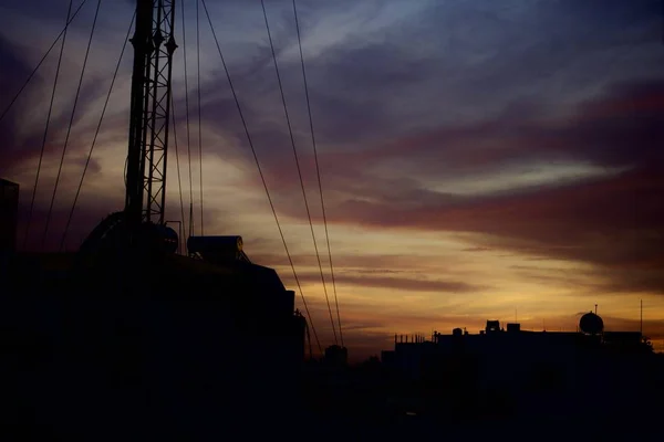Scatto paesaggistico di edifici in silhouette con il cielo al tramonto sullo sfondo — Foto Stock