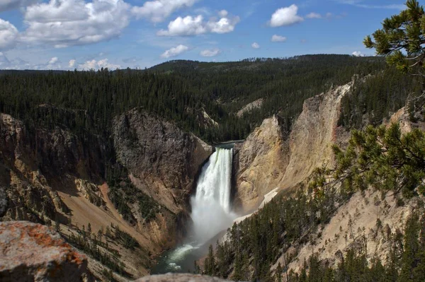 Scatto paesaggistico di una cascata che scorre dalle scogliere di una montagna in un fiume — Foto Stock