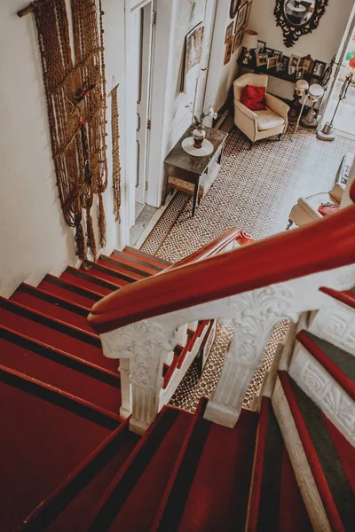 Vertical shot of red stairs leading to a vintage room interior