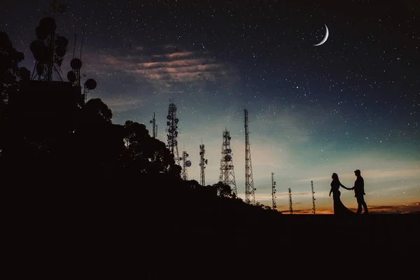 Οριζόντια βολή ενός άνδρα και μιας γυναίκας σε σιλουέτα κρατώντας τα χέρια κάτω από τον έναστρο νυχτερινό ουρανό — Φωτογραφία Αρχείου