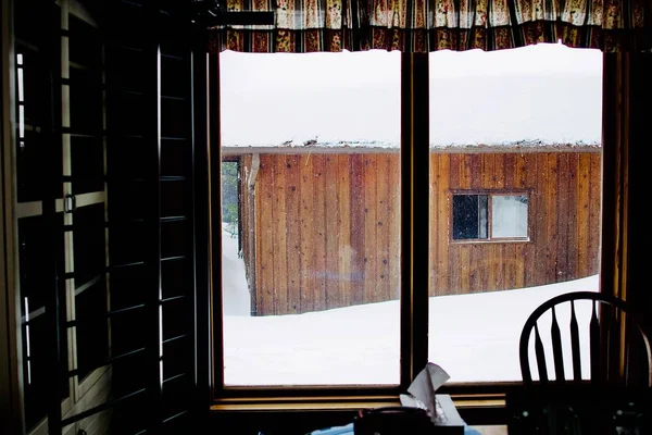 Karla kaplı ahşap bir barakanın olduğu evin içinden güzel bir çekim. — Stok fotoğraf