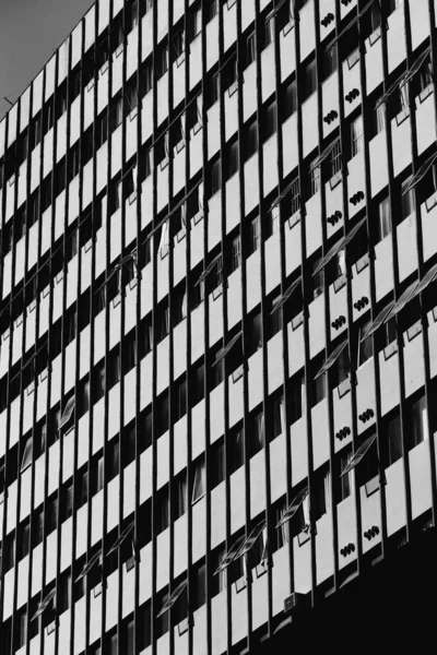 Vertikale Aufnahme einer Gebäudeseite mit großen offenen Fenstern — Stockfoto