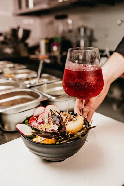 Вертикальний крупним планом знімок миски, повний їжі та келиха вина, повного червоного вина в ресторані — стокове фото