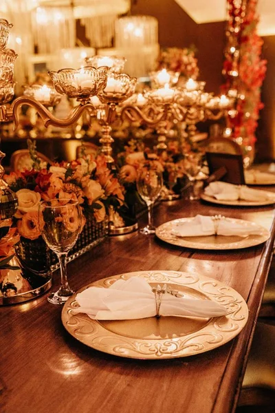 Вертикальний знімок столу з тарілками, тканинами, келихами для вина та настільними лампами на ньому — стокове фото