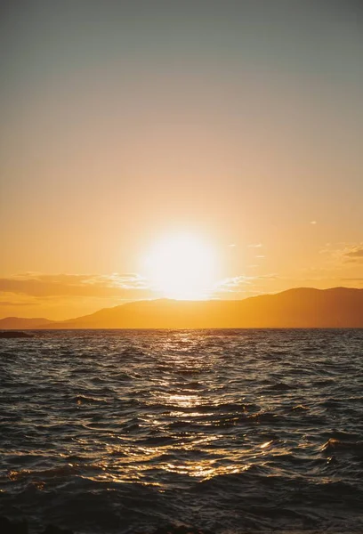 Colpo verticale del mare con lo sfondo del bellissimo tramonto la sera — Foto Stock