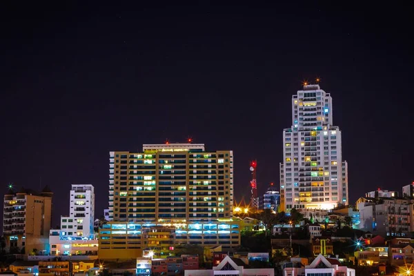 Wide shot of high-rise buildings with lights in a big city at night time — Stock fotografie