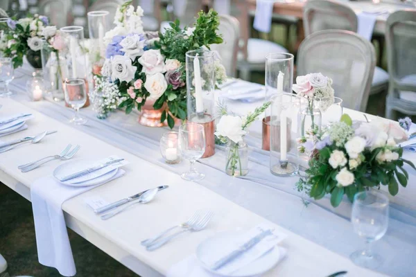 결혼식 피로연을 위한 꽃꽂이와 양초가 있는 아름다운 옥외 식탁 — 스톡 사진