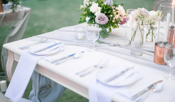 Beautiful outdoor table setting with floral decorations and candles for a wedding reception — Stock Photo, Image