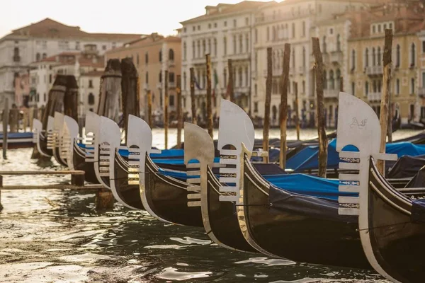 Plan rapproché de bateaux près du quai sur l'eau avec des bâtiments flous en arrière-plan pendant la journée — Photo