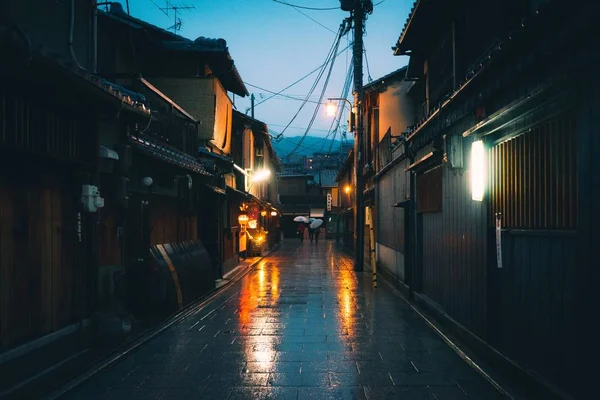 Poziome ujęcie pustej ścieżki pomiędzy domami w Japonii w nocy podczas deszczu — Zdjęcie stockowe