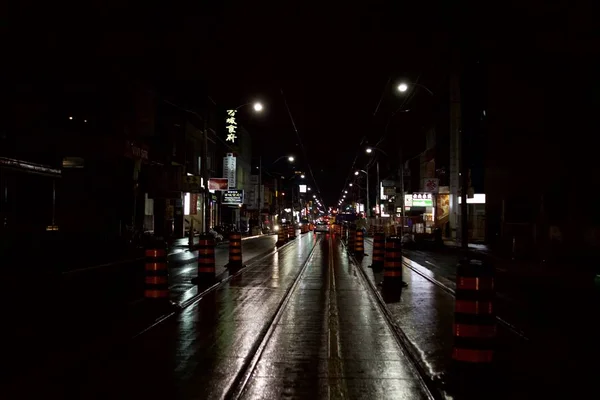 Foto horizontal de una calle en una ciudad durante la noche con un coche en la distancia —  Fotos de Stock