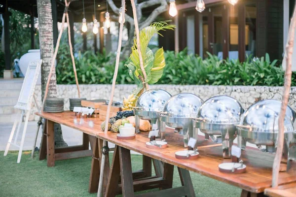 Horizontale opname van een trouwtafel buiten met zilveren potten en veel borden — Stockfoto