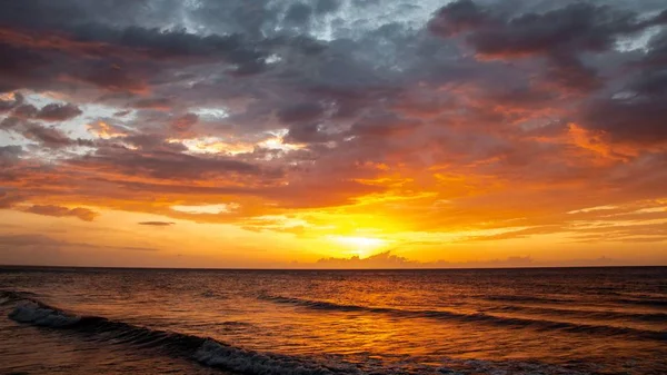 Bulutların arkasındaki nefes kesen günbatımının geniş bir görüntüsü akşam vakti güzel denizi yansıtıyor. — Stok fotoğraf