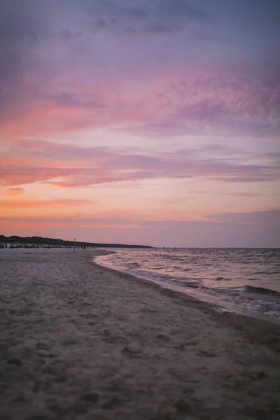 Plan vertical du bel océan sous le ciel coloré dans la soirée — Photo