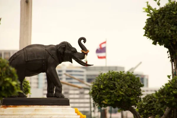 Selektive Fokusaufnahme einer Bronze-Elefantenstatue mit der thailändischen Nationalflagge im Hintergrund — Stockfoto