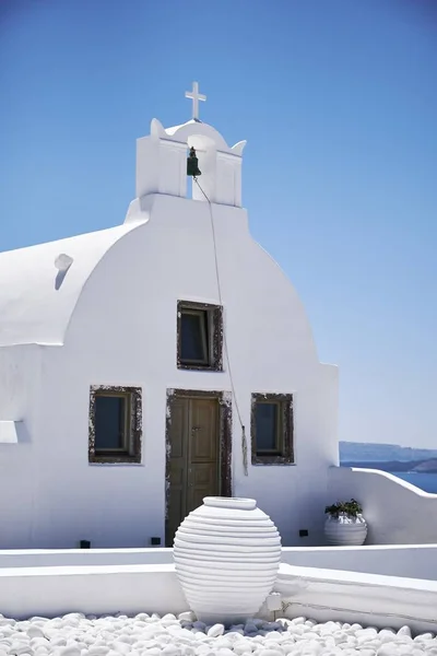 在美丽的蓝天下，圣托里尼岛上的一个白色混凝土小礼拜堂的垂直拍摄 — 图库照片
