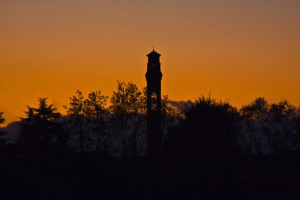 Силуэт колокольни с оранжевым небом на заднем плане — стоковое фото
