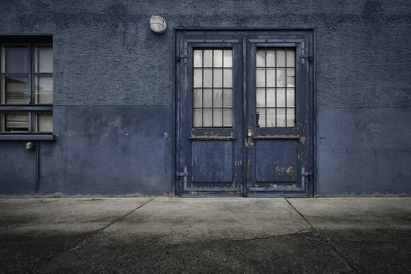 Primer plano de una vieja puerta de madera de un edificio azul durante el día — Foto de Stock