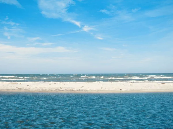 Wide shot of the beautiful blue sea and the white sand during daytime under the cloudy sky — Stock Photo, Image