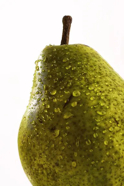 Selektive Nahaufnahme einer grünen Birne mit Wassertropfen auf weißem Hintergrund — Stockfoto