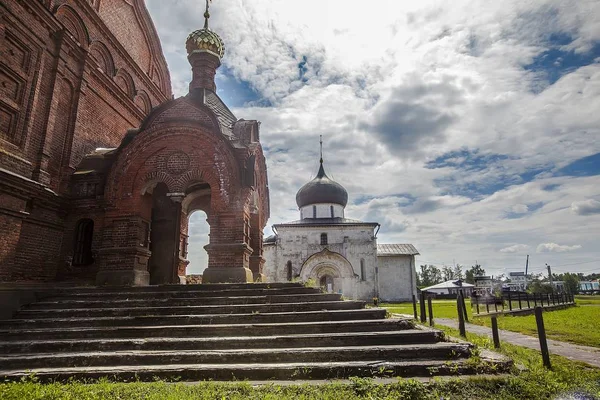 Horizontální záběr kostela z červených cihel s dalším kostelem v pozadí v Jurjevě-Polském — Stock fotografie