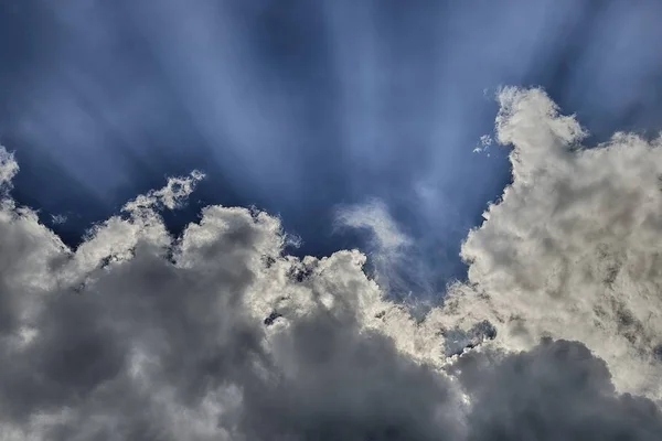 Sudut rendah ditembak matahari bersinar di belakang awan di langit biru — Stok Foto