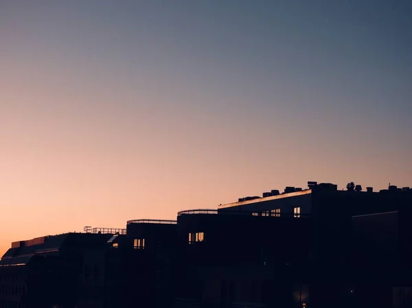 Tiro horizontal de edifícios altos sob o céu colorido durante o pôr do sol — Fotografia de Stock