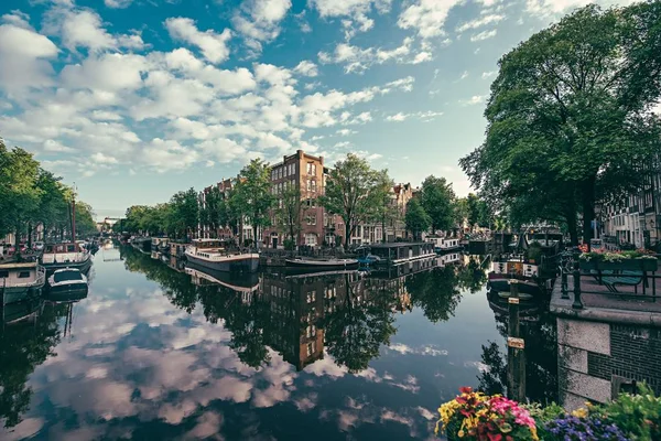 Amplio plano de un lago claro con el reflejo de nubes rodeadas de edificios altos en Amsterdam — Foto de Stock