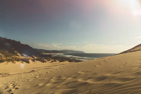 晴れた空の下で水によって砂漠の丘の美しいワイドショット — ストック写真