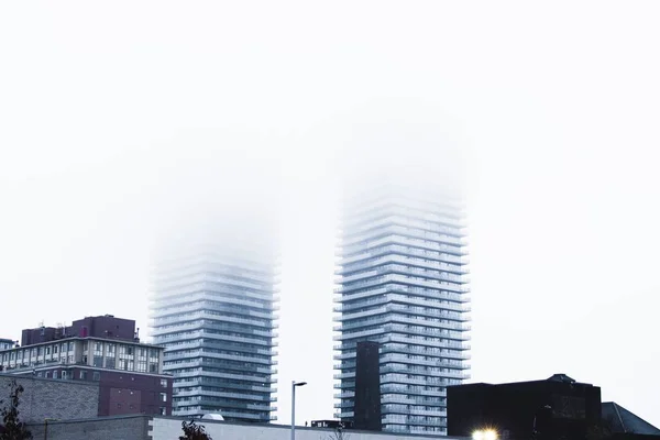 Широкий знімок сірої архітектурної висотної будівлі, вкритої туманами — стокове фото