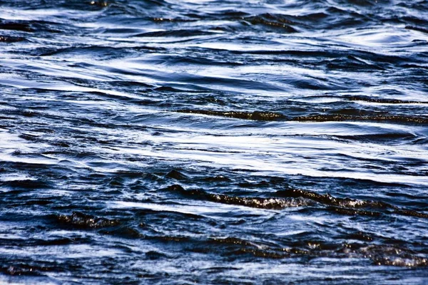 Primer plano de un mar con pequeñas olas durante el día — Foto de Stock