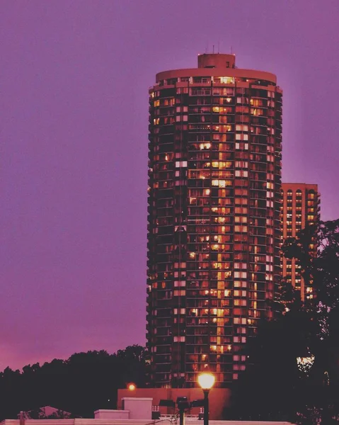 Imagen vertical de un edificio iluminado de gran altura durante la noche —  Fotos de Stock