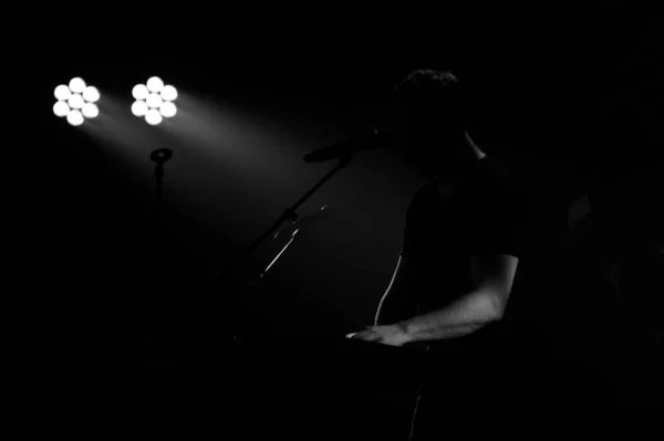 音乐家在话筒台前弹奏键盘的黑白镜头 — 图库照片